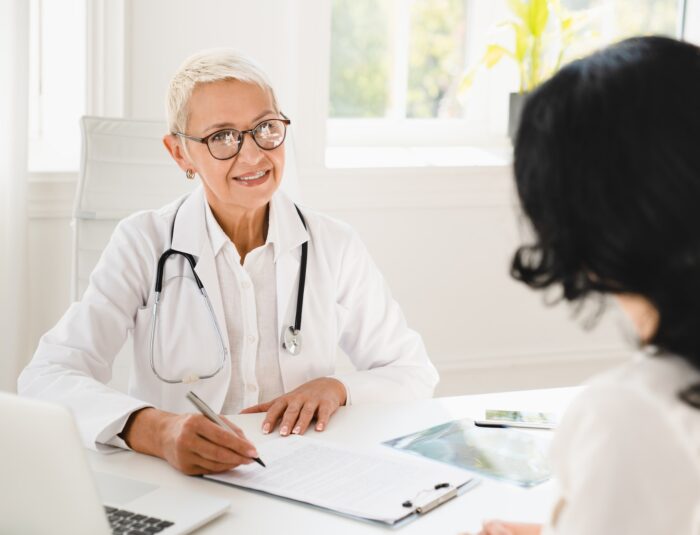 Gynecologist prescribing medicines, health insurance with female patient during hospital appointment